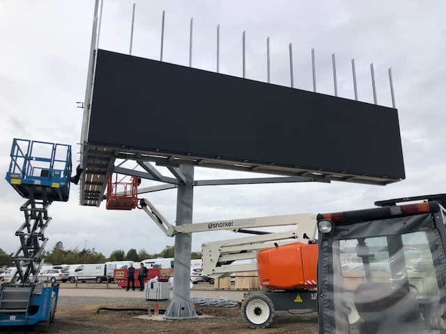 LED-Module werden von Arbeitsbühnen aus in die Stahlkonstruktion eingesetzt