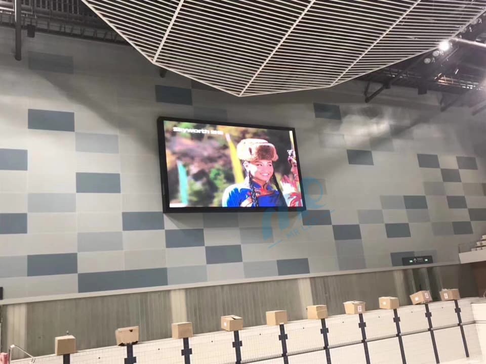 LED-Tafel an der Wand einer Sporthalle über Sitzplätzen