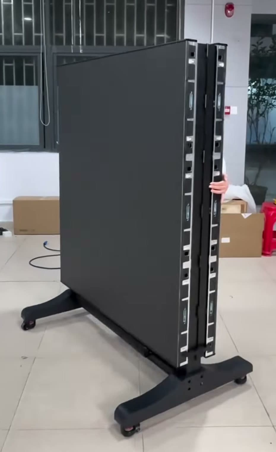 Rückseite eines zusammengefalteten mobilen LED-Bildschirms auf einem Rollständer mit sichtbarem Arm