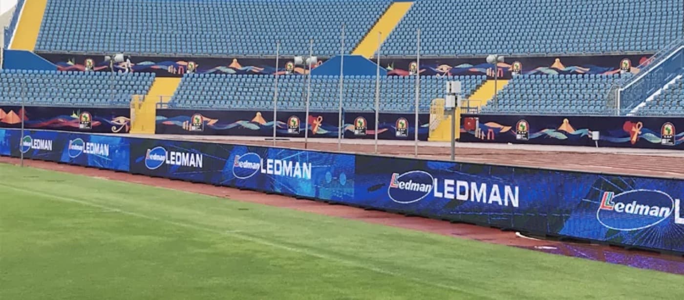 LED-Bande entlang der Seitenlinie eines Fußballstadions vor einer Tribüne