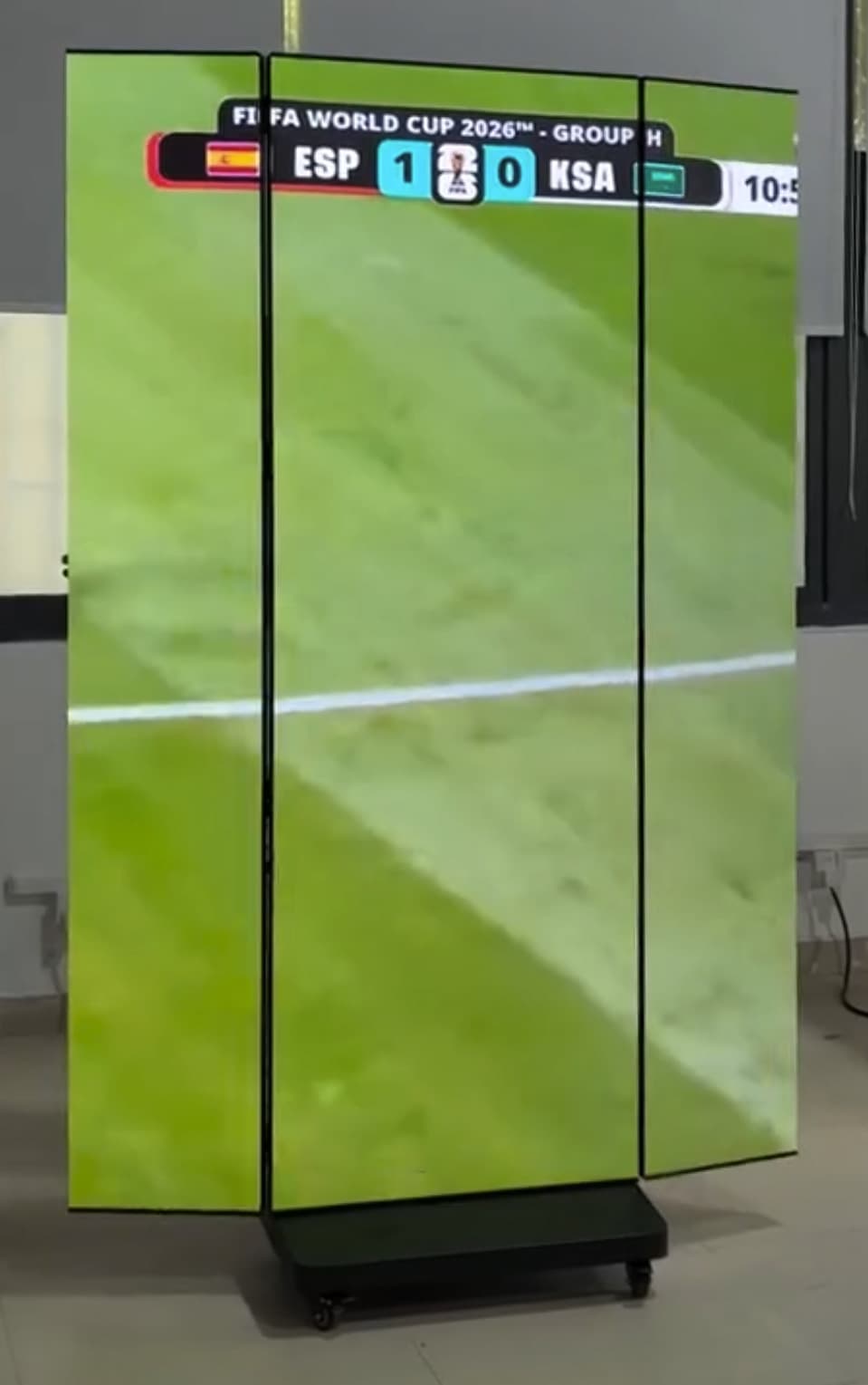 LED-Faltposter mit zwei schräg gestellten Seitenflächen und Fußballbild auf einem Rollfuß. Standbild aus einem Video.